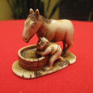 Antique carved japanese ivory Netsuke of a boy washing a horse