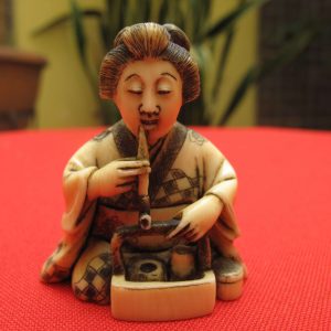 Antique carved japanese ivory Netsuke of a woman smoking his pipe